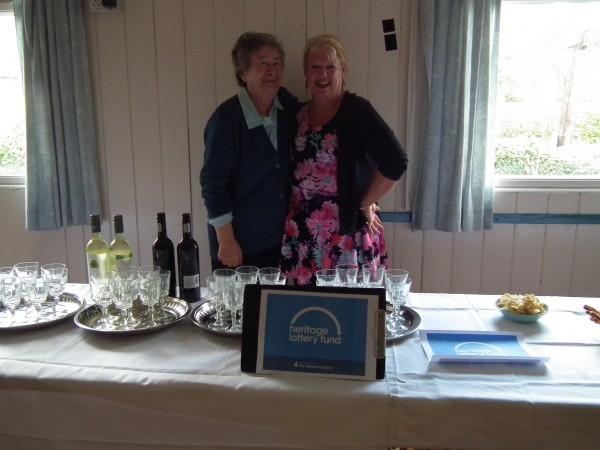 Two ladies standing and smiling at camera