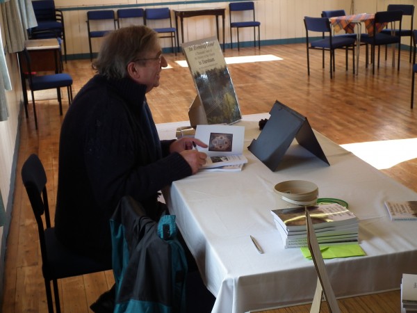 A man seated at a table with the new book
