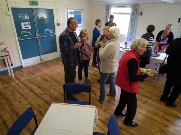 A group of people at the launch chatting inside the village hall