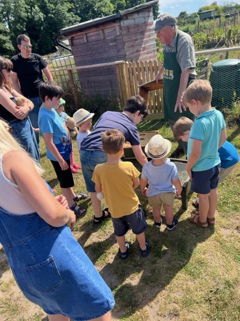 A group of people at the Orchard learn about bees