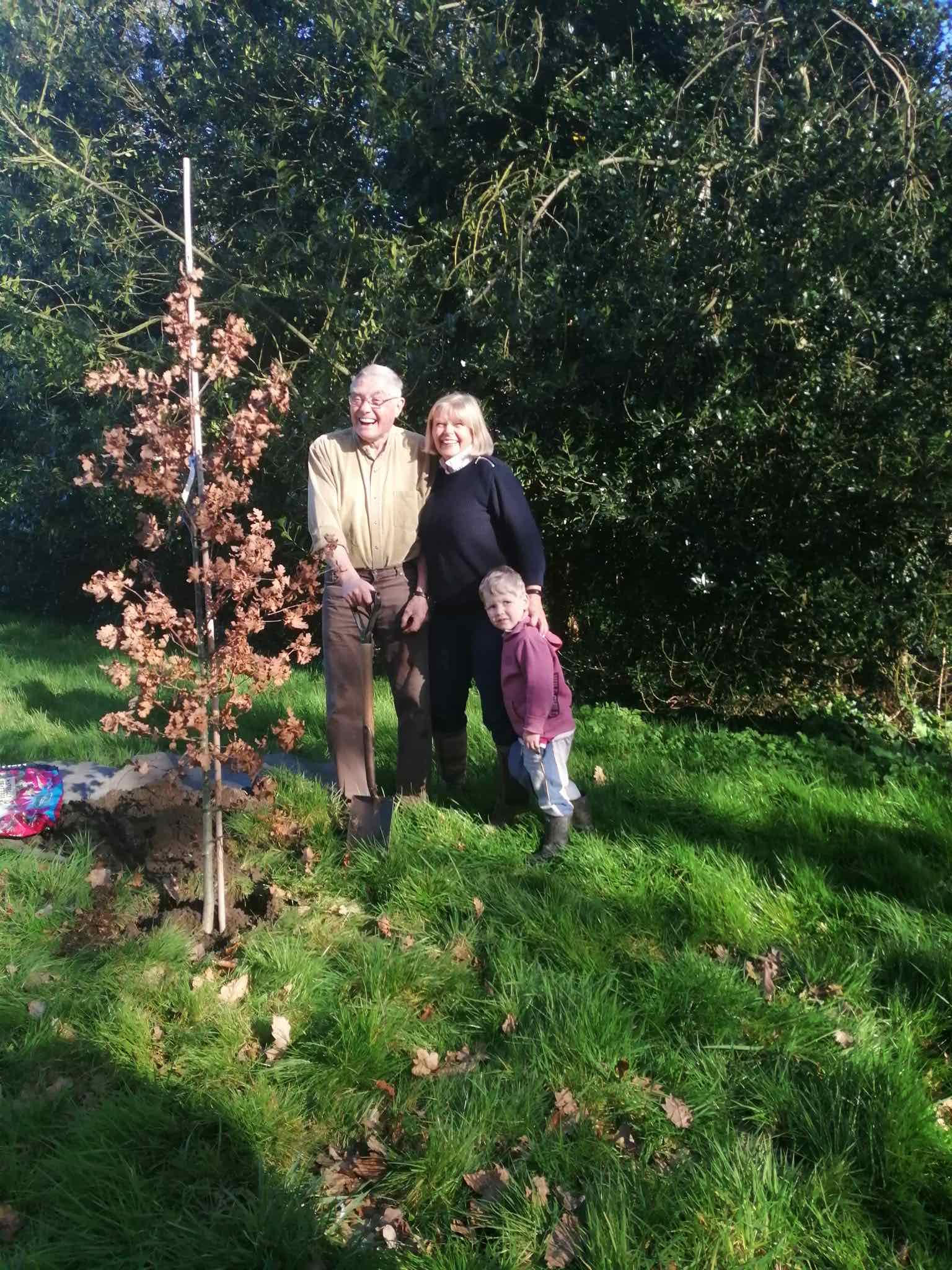 Roger Coates-Smith, Jasmine Backhouse and her grandson stand next to the jubilee tree
